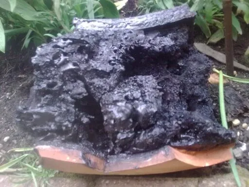 Lump of tar and broken clay liner removed from a flue during reaming
