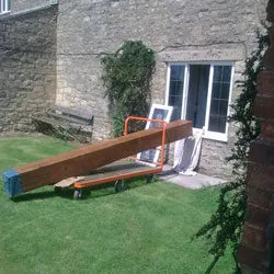 Replacement oak beam on a trolley in the garden, ready to be fitted